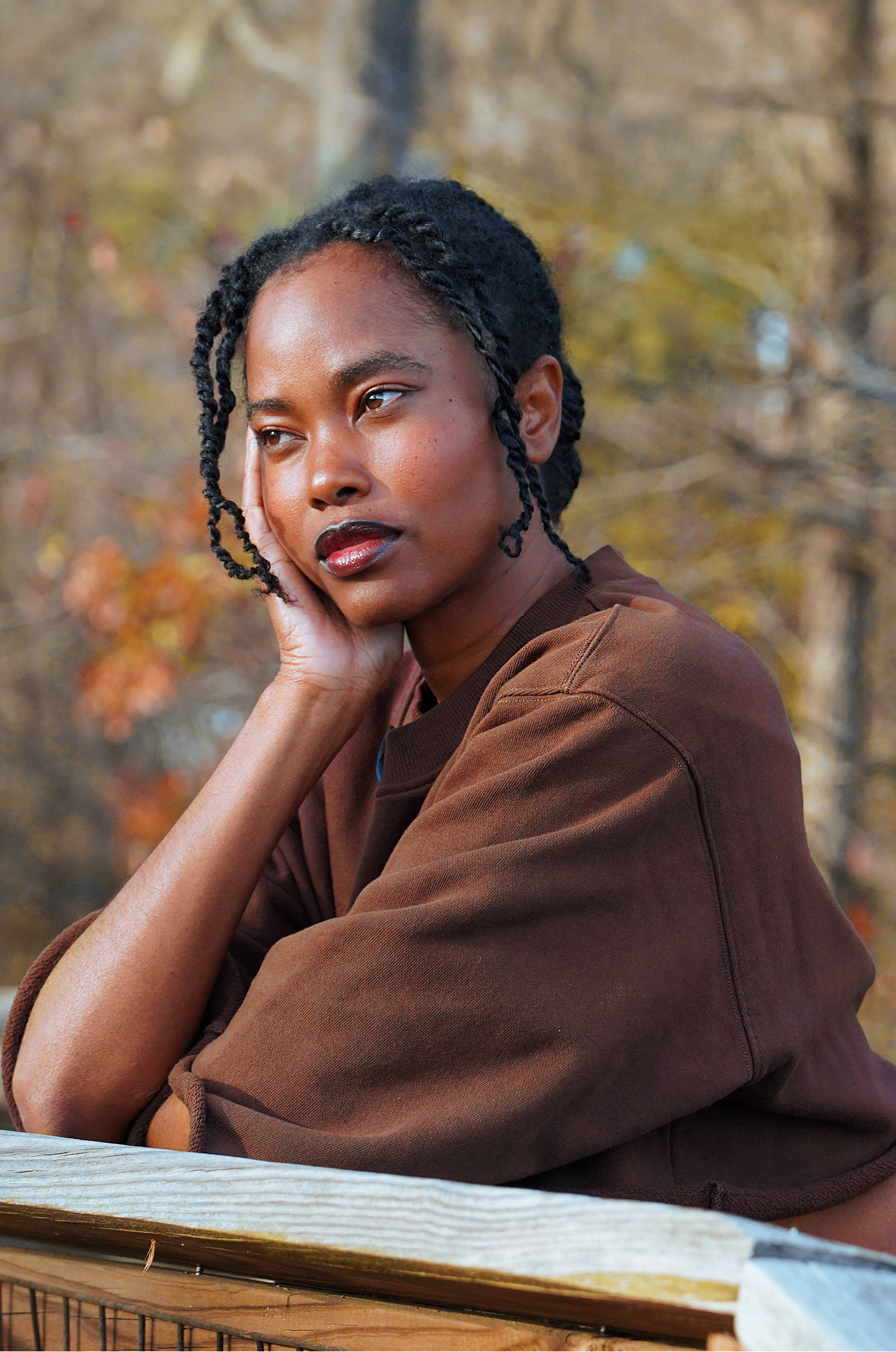 Woman sitting on a wooden bench in a forest during autumn